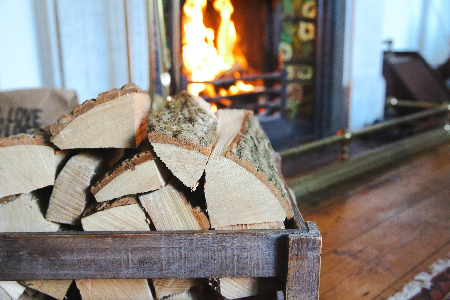 Hardwood logs piled in front of an open fire