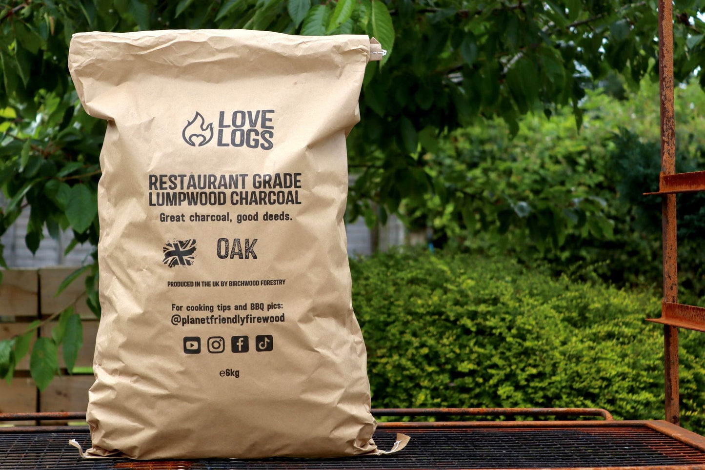 A brown paper bag which reads 'Love Logs Restaurant Grade Lumpwood Charcoal'