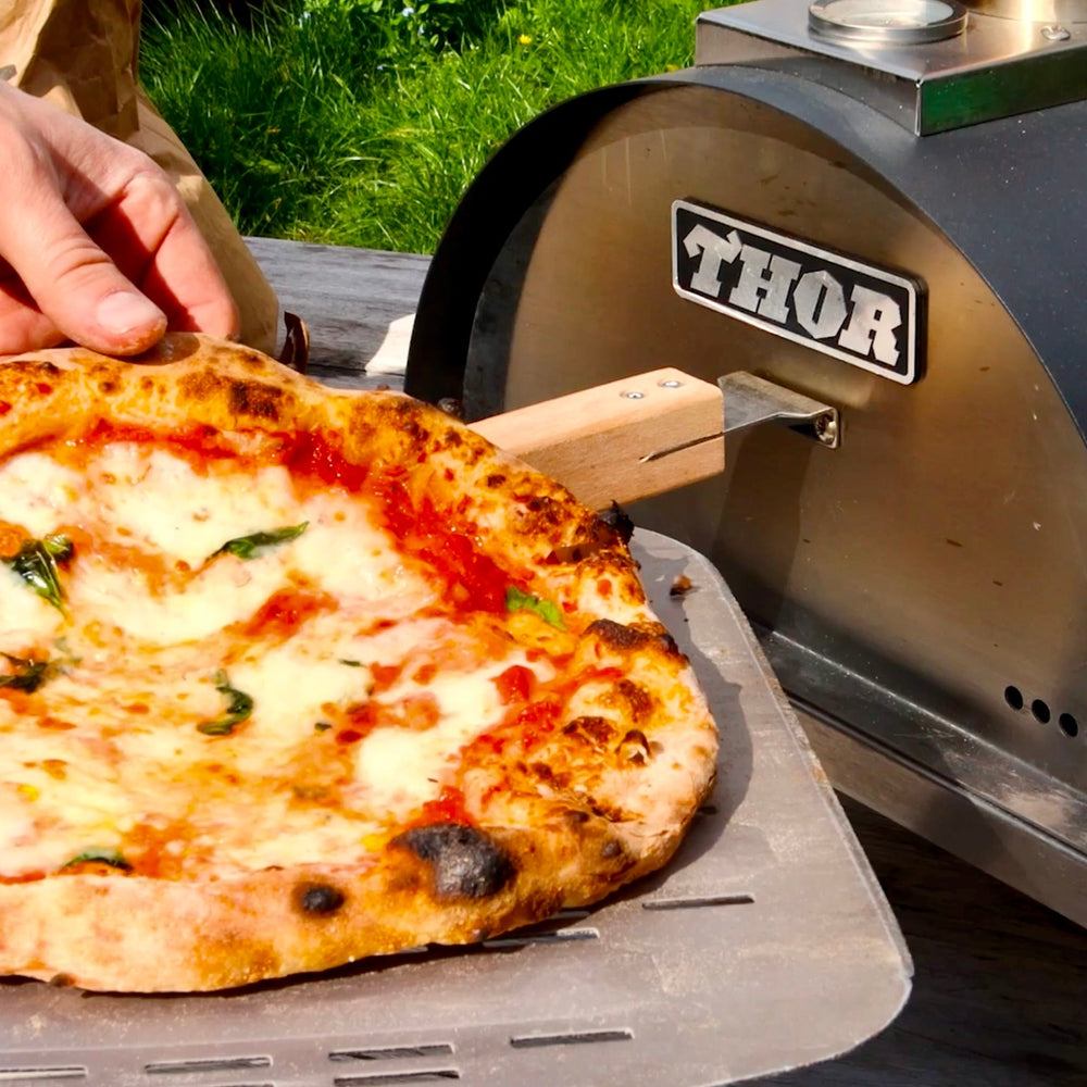 A wood fired Neapolitan Margherita pizza baked in the Thord pizza oven, also shown