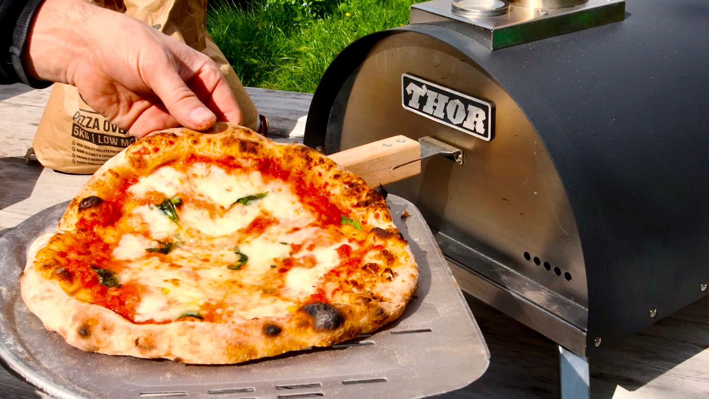 A wood fired Neapolitan Margherita pizza baked in the Thord pizza oven, also shown