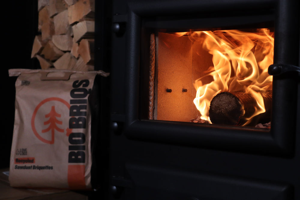 Bio Briqs firewood briquette on fire in log burner with bag in background