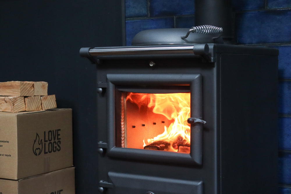 Lit Log Burner with Love Logs Wood in Background